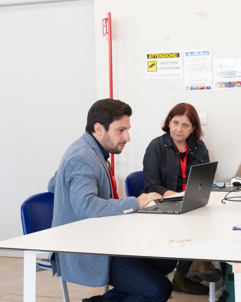 Cristiano Fanelli al computer insieme a una partecipante durante il lavoro nei gruppi